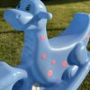 Kolorowa huśtawka dla dzieci w kształcie delfina, wykonana z wytrzymałego plastiku, idealna na plac zabaw oraz do ogrodu, zapewniająca bezpieczną i radosną zabawę dla najmłodszych.