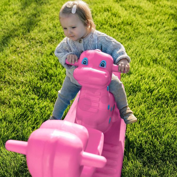 WOOPIE-Bujak-Wieloosobowy-Dino-Hustawka-Rownowazna-Rozowa-4 Radosne dziecko na huśtawce w kształcie różowej konia, zabawa na świeżym powietrzu, dziecięce chwile szczęścia, ogród z zieloną trawą, outdoorowe atrakcje dla dzieci.